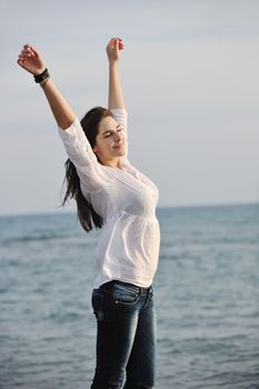 happy young woman relax on beautiful  beach at fresh summer morning and enjoy first ray of sun