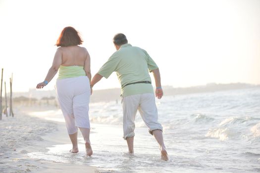 happy senior mature elderly people couple have romantic time on beach at sunset 