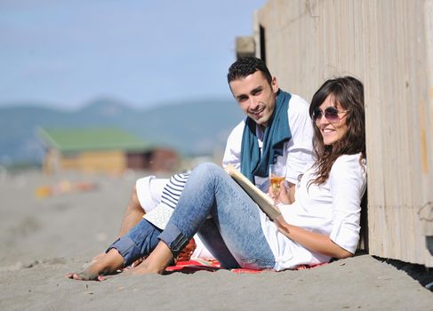 happy young couple enjoying  picnic on the beach and have good time on summer vacations