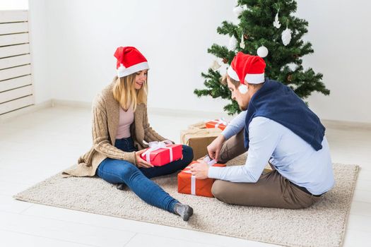 Holidays, family and festive concept - Couple with Christmas gifts at home.