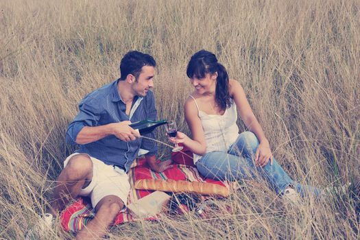 happy young couple enjoying  picnic on the countryside in the field  and have good time