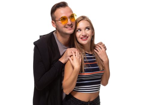 Happy young lovely couple standing together and laughing. Studio shot over white background. Friendship, love and relationships concept