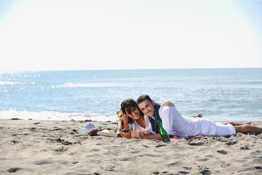 happy young couple enjoying  picnic on the beach and have good time on summer vacations