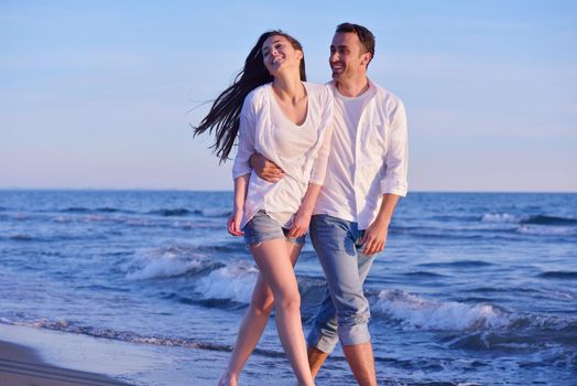 happy young romantic couple in love have fun on beautiful beach at beautiful summer day