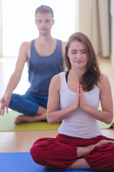 Young healthy couple in yoga position on white background.