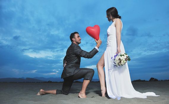 happy just married young couple celebrating and have fun at beautiful beach sunset