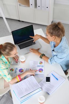 Two women working together at office, sitting