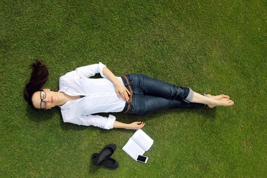 Young student woman reading a book and study in the park