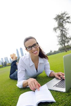 happy young student woman with laptop in city park study