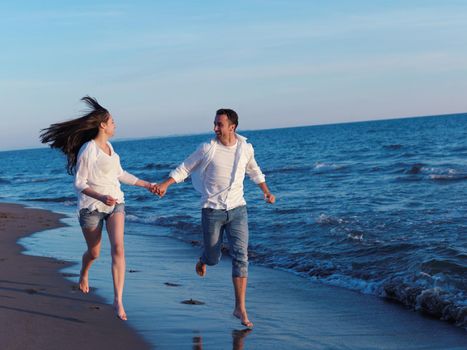 happy young romantic couple in love have fun on beautiful beach at beautiful summer day