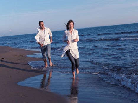 happy young romantic couple in love have fun on beautiful beach at beautiful summer day