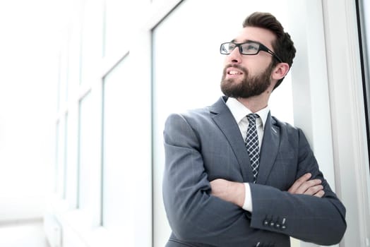 close up.portrait of a confident businessman standing in a bright office.