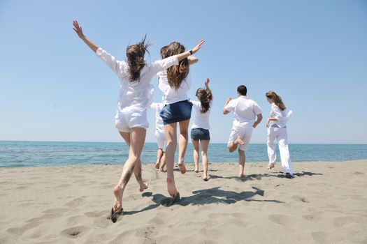 happy people group have fun  run and jump  on beach beautiful sand  beach