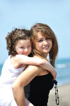 group portrait of happy childrens with young female  teacher on beach