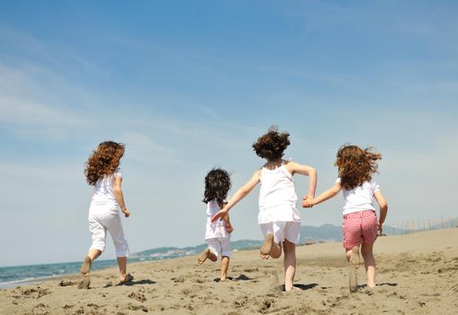 group of happy child on beach who have fun and play games