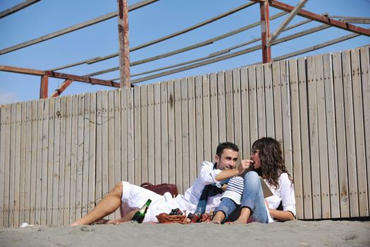 happy young couple enjoying  picnic on the beach and have good time on summer vacations