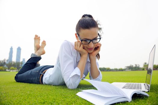 happy young student woman with laptop in city park study