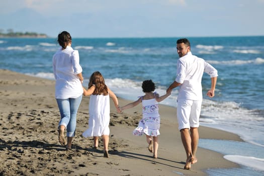 happy young family in white clothing have fun at vacations on beautiful beach 