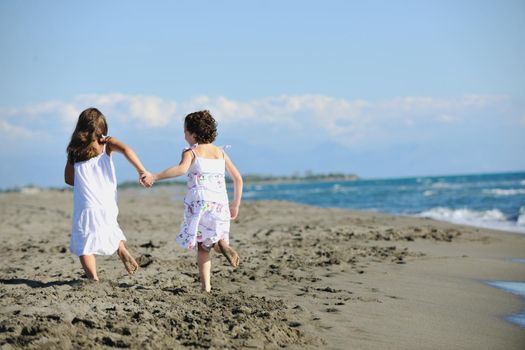 happy two little girls have fun and joy time at beautiful beach while running from joy 