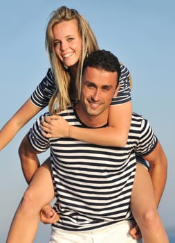 happy young couple have romantic time on beach at sunset