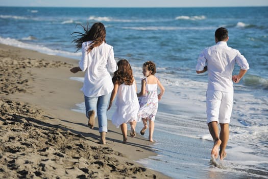 happy young family in white clothing have fun at vacations on beautiful beach 