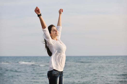 happy young woman relax on beautiful  beach at fresh summer morning and enjoy first ray of sun