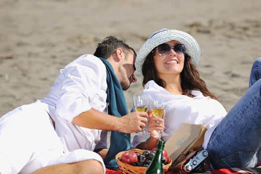 happy young couple enjoying  picnic on the beach and have good time on summer vacations