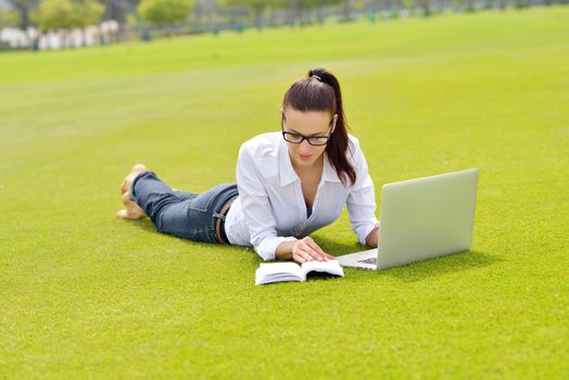 happy young student woman with laptop in city park study