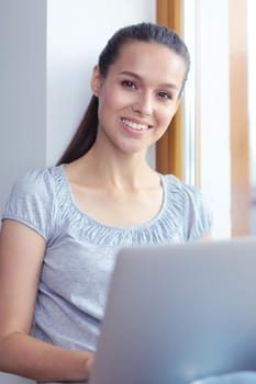 Young beautiful woman using a laptop computer at home. Young beautiful woman