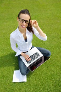 happy young student woman with laptop in city park study