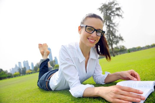 Young student woman reading a book and study in the park