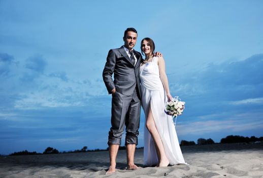 happy just married young couple celebrating and have fun at beautiful beach sunset