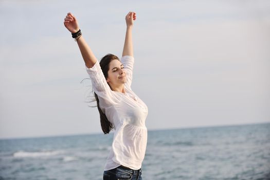 happy young woman relax on beautiful  beach at fresh summer morning and enjoy first ray of sun