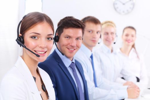 Attractive positive young businesspeople and colleagues in a call center office