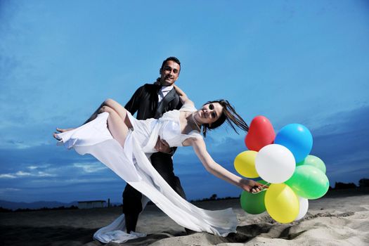 happy just married young couple celebrating and have fun at beautiful beach sunset