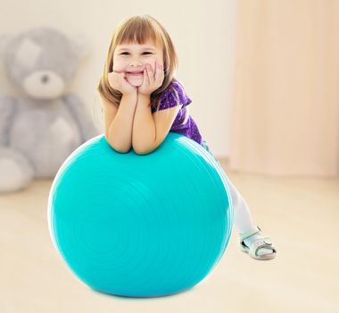 About what dreams a little girl , put his hands on big blue fitness ball.In the children's room where sits a large Teddy bear .