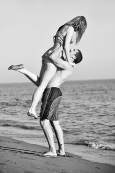 happy young couple have romantic time on beach at sunset