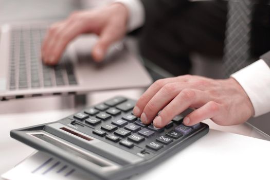 close up.businessman makes calculations on the calculator. accounting and technology