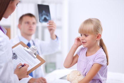 Female doctor examining child with stethoscope at surgery.