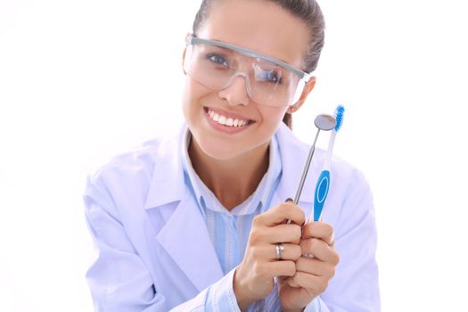 Beautiful female dentist doctor holding and showing a toothbrush isolated on a white background. Dentist doctor.