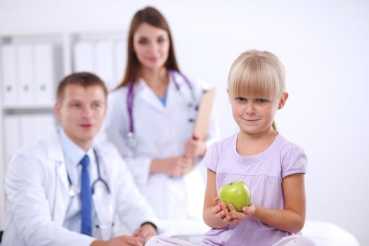 Female doctor examining child with stethoscope at surgery.