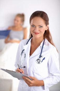 Smiling female doctor with a folder in uniform standing