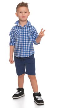 Cheerful little boy in a plaid shirt and blue shorts shows hand sign, Victoria - Isolated on white background