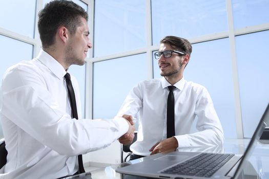 Two businessmen are sitting in the office and discussing the conclusion of a new deal