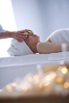 Young woman lying on a massage table,relaxing with eyes closed. Woman. Spa salon.