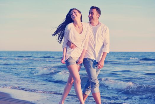 happy young romantic couple in love have fun on beautiful beach at beautiful summer day