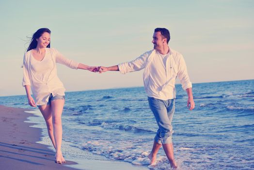 happy young romantic couple in love have fun on beautiful beach at beautiful summer day