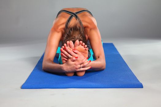 Portrait of sport girl doing yoga stretching exercise .