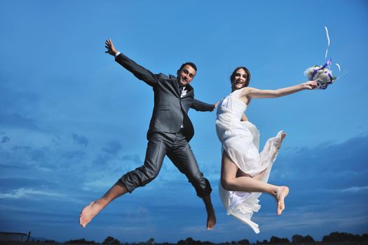 happy just married young couple celebrating and have fun at beautiful beach sunset