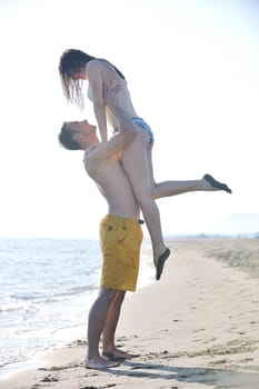 happy young couple have romantic time on beach at sunset